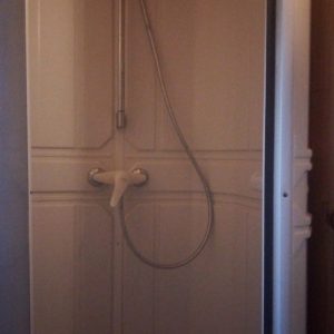 Douche spacieuse dans un hébergement insolite, avec des murs en bois et une ambiance chaleureuse.