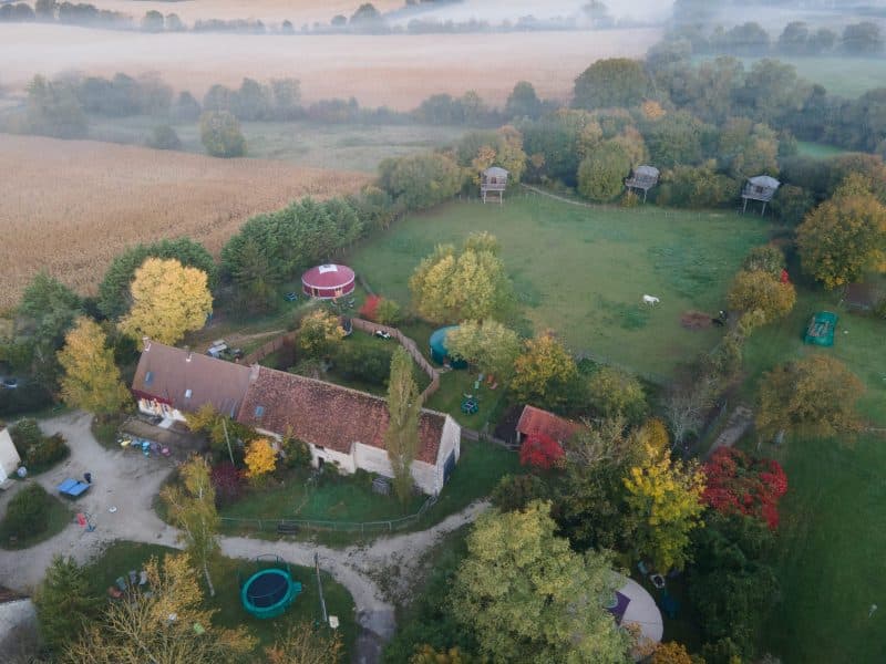 Gîte rural avec vue sur la nature, entouré darbres et dun grand jardin.