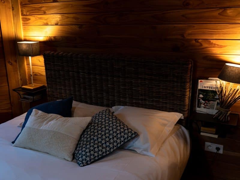 Chalet en bois chaleureux avec lit douillet et éclairage tamisé.