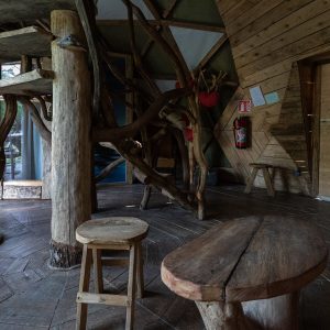 Intérieur d'une cabane en bois, avec des meubles rustiques et des éléments naturels.