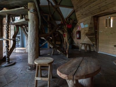 Intérieur d'une cabane en bois, avec des meubles rustiques et des éléments naturels.