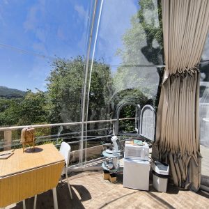 Hébergement insolite : bulle transparente avec vue sur la nature, décor moderne et lumineux.