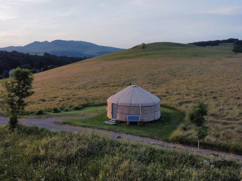 Yourte spacieuse au milieu des collines verdoyantes, offrant une vue panoramique apaisante.