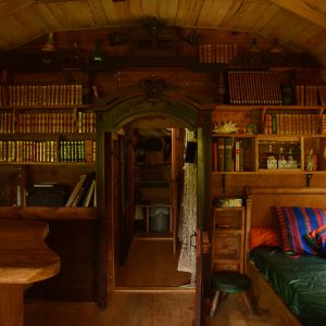 Intérieur chaleureux d'une cabane en bois, avec des étagères remplies de livres et un coin salon