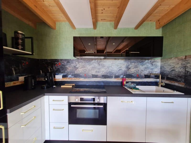 Cuisine moderne dun chalet, avec des poutres en bois et un plan de travail élégant.