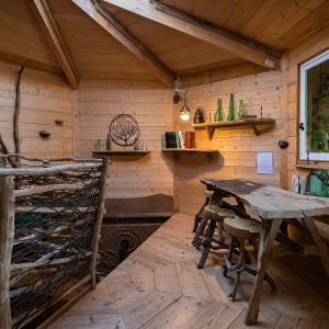 Cabane en bois chaleureuse avec un intérieur en bois clair et une table rustique.