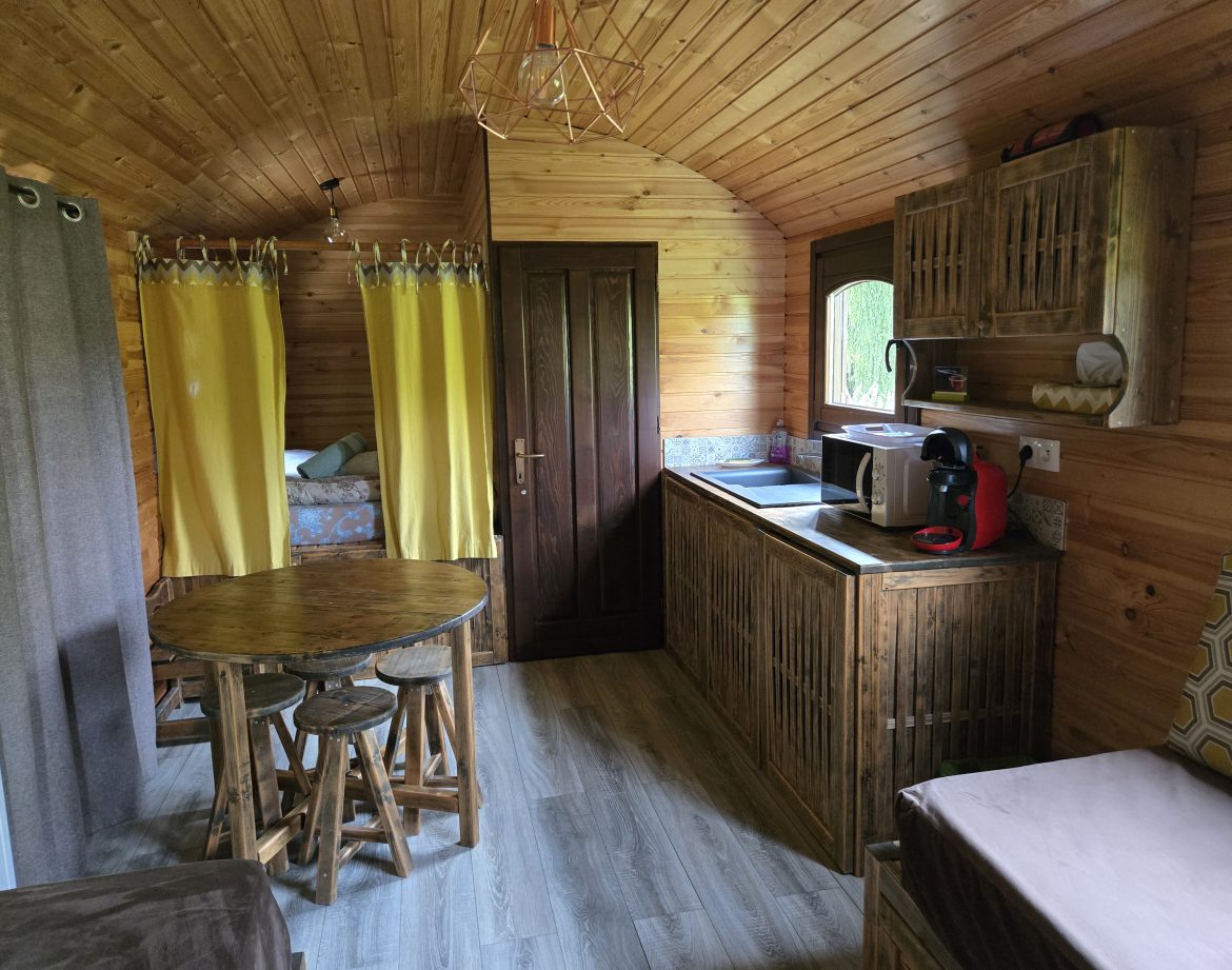 Un charmant chalet en bois avec cuisine équipée et décoration chaleureuse.