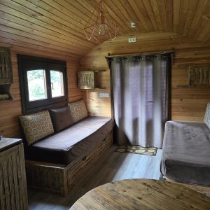 Intérieur d'une cabane en bois, avec canapés confortables et ambiance chaleureuse.