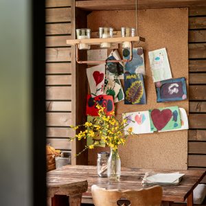 Un chalet en bois chaleureux avec des œuvres d'art colorées et une table en bois accueillante.