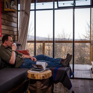Un chalet moderne avec vue, où l'on peut se détendre avec un livre et une tasse de café.