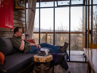 Un chalet moderne avec vue, où l'on peut se détendre avec un livre et une tasse de café.
