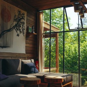 Un chalet moderne avec de grandes fenêtres, offrant une vue sur la nature verdoyante.