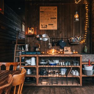Cabane chaleureuse en bois, avec une cuisine rustique et des lumières tamisées.
