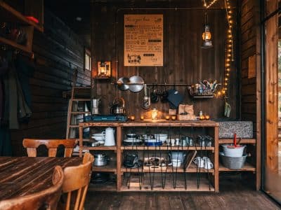 Cabane chaleureuse en bois, avec une cuisine rustique et des lumières tamisées.
