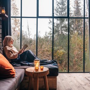 Un chalet moderne avec de grandes fenêtres, offrant une vue sur la nature, idéal pour se détendre.