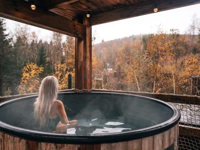 Bain nordique en bois, avec vue sur la forêt automnale et une ambiance relaxante.