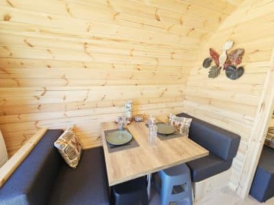 Intérieur chaleureux d'un chalet en bois, avec table en bois et banquettes confortables.