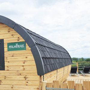 Cabane en bois avec terrasse, offrant une vue panoramique sur la nature environnante.