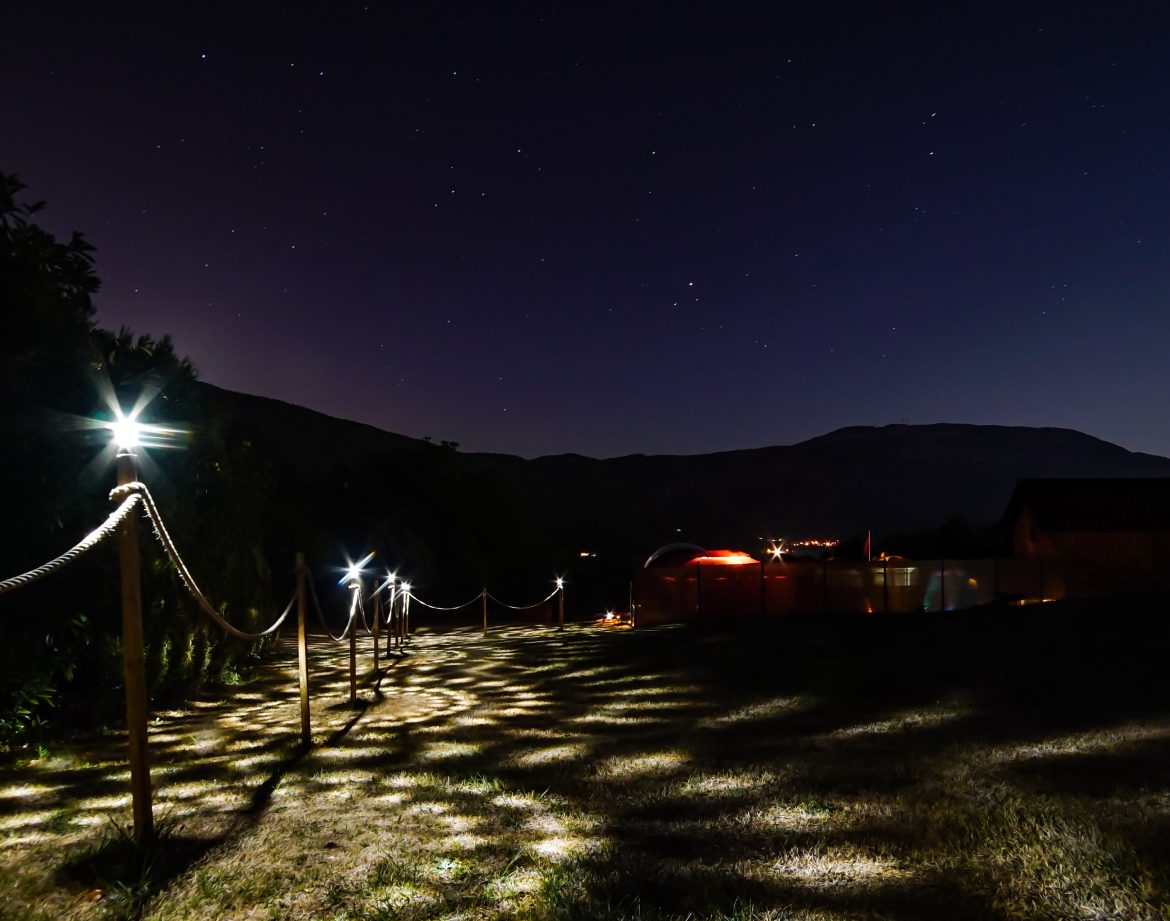 Hébergement insolite sous les étoiles, avec un chemin lumineux menant à des structures uniques.