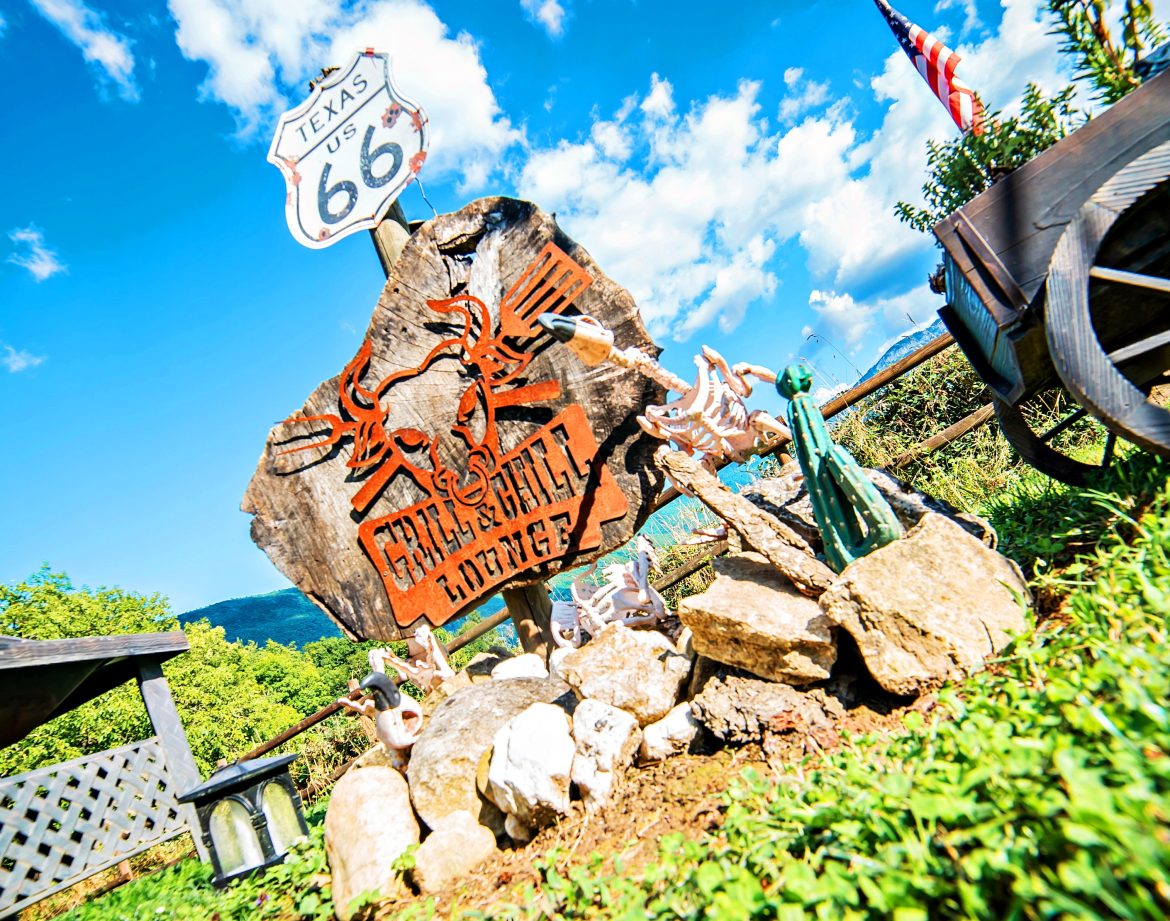 Hébergement insolite : cabane décorée sur Route 66, avec sculptures et paysage verdoyant.