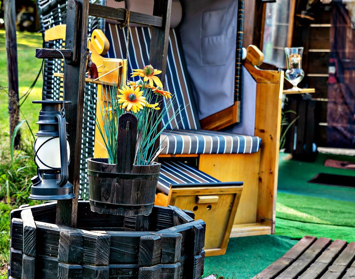 Hébergement insolite : un charmant puits décoratif avec des fleurs, près d'une cabane accueillante.