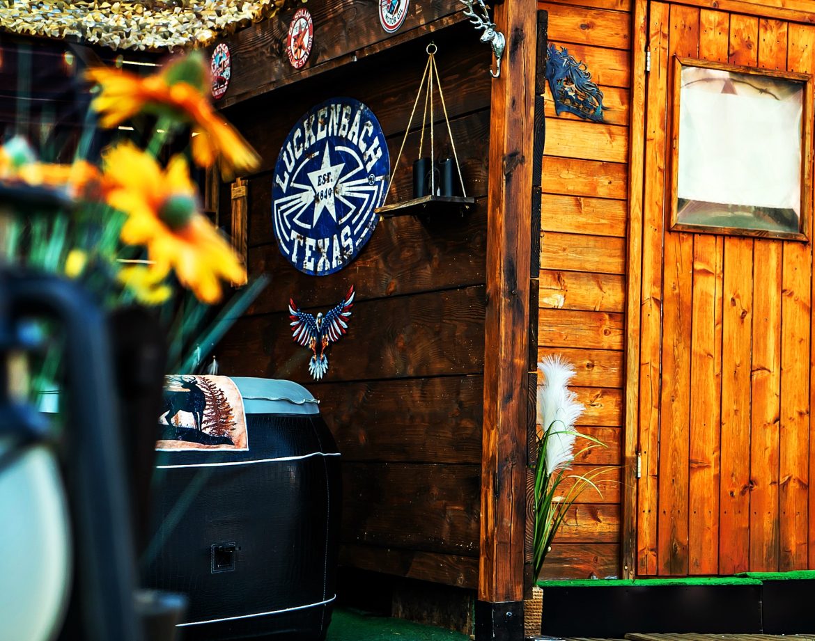 Cabane en bois chaleureuse avec décorations artisanales et fleurs colorées en avant-plan.