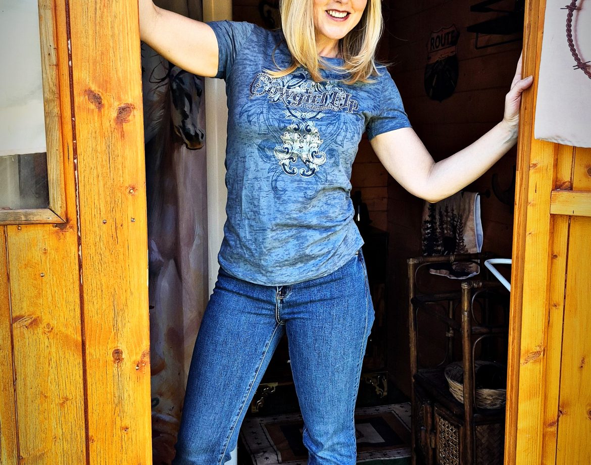 Cabane en bois avec une hôtesse en cowboy, chapeau noir et pistolet en plastique à la main.