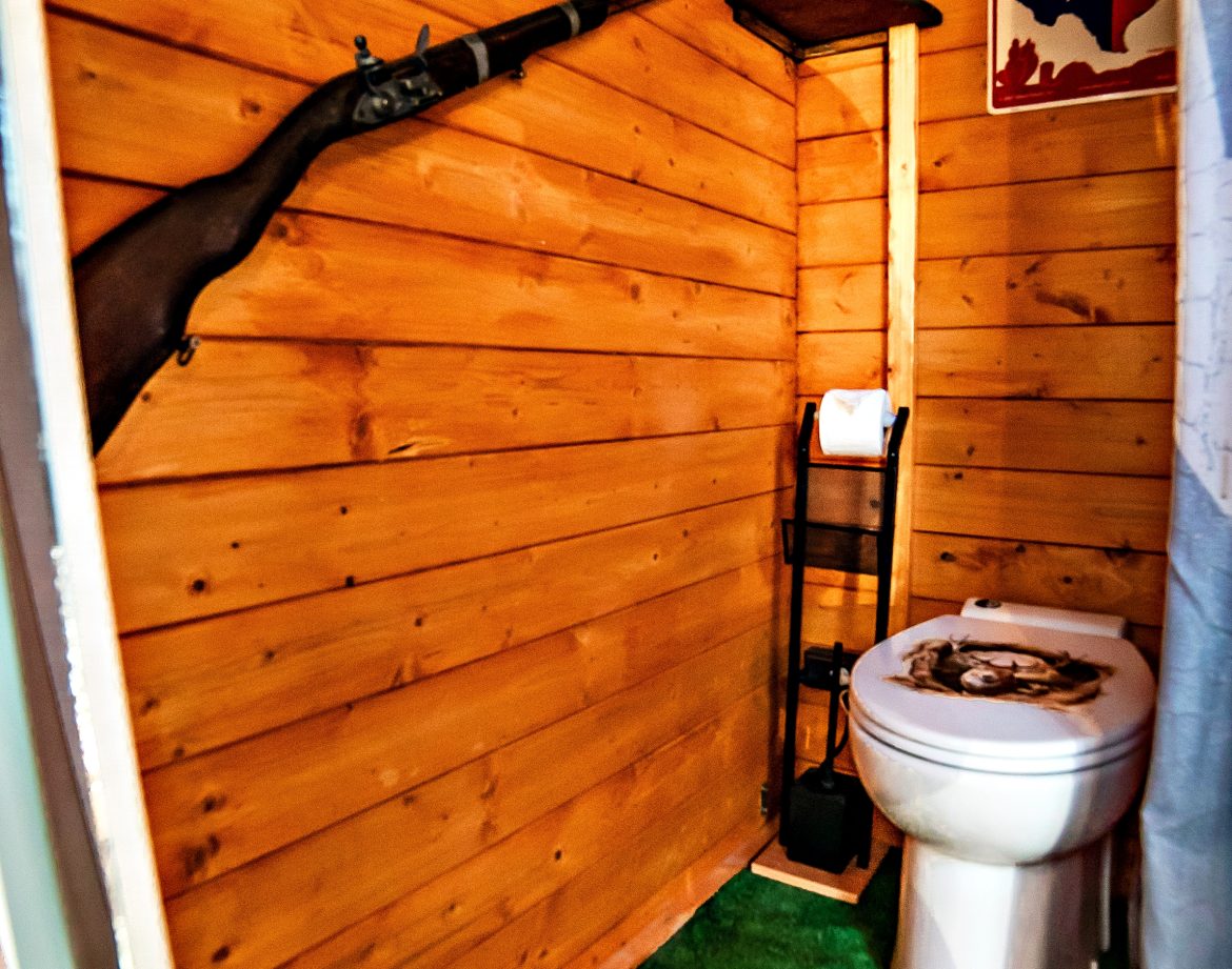 Toilettes en bois décorées de souvenirs texans, ambiance rustique et originale.