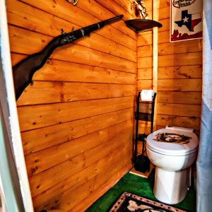 Toilettes en bois décorées de souvenirs texans, ambiance rustique et originale.
