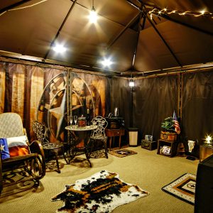 Tente confortable avec décoration rustique, éclairage doux et coin salon accueillant.