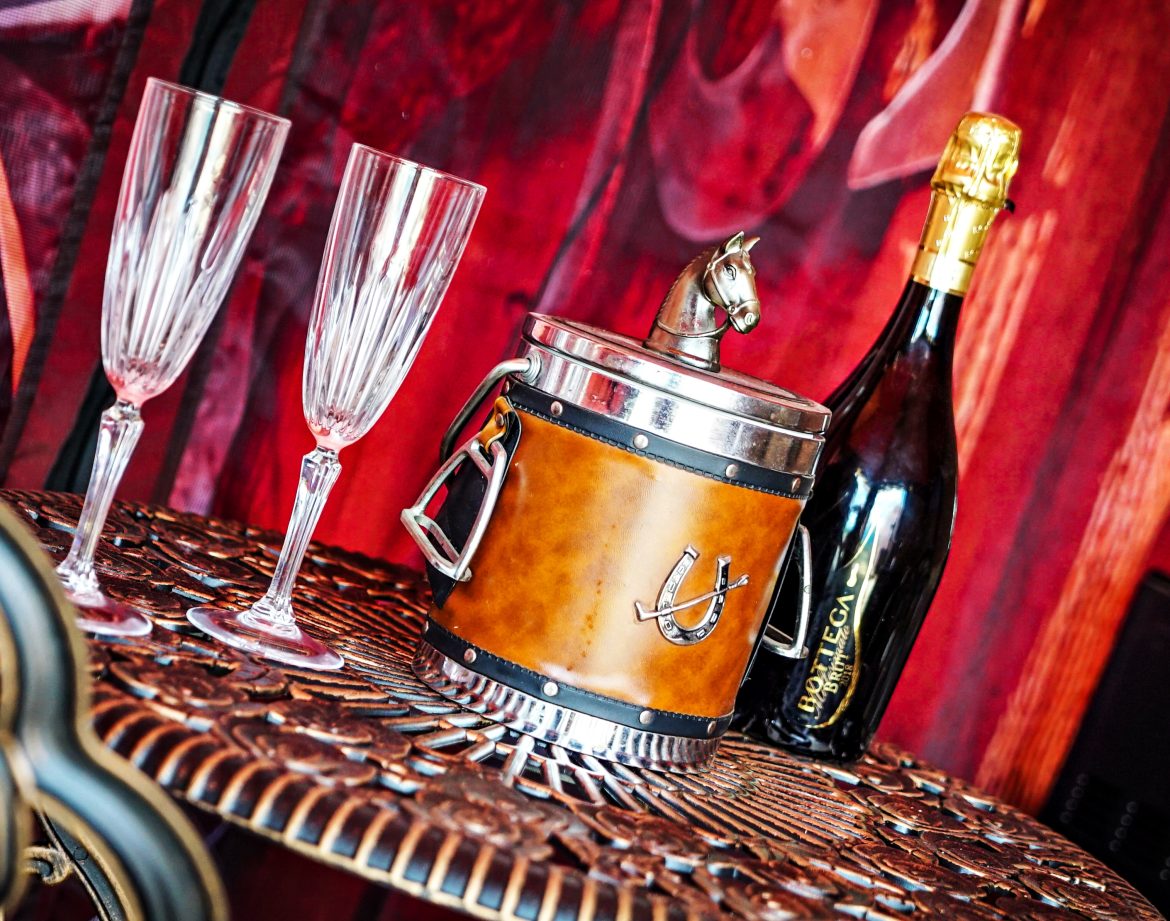 Un hébergement insolite avec un seau à champagne en cuir et des flûtes élégantes.