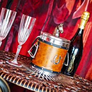 Un hébergement insolite avec un seau à champagne en cuir et des flûtes élégantes.