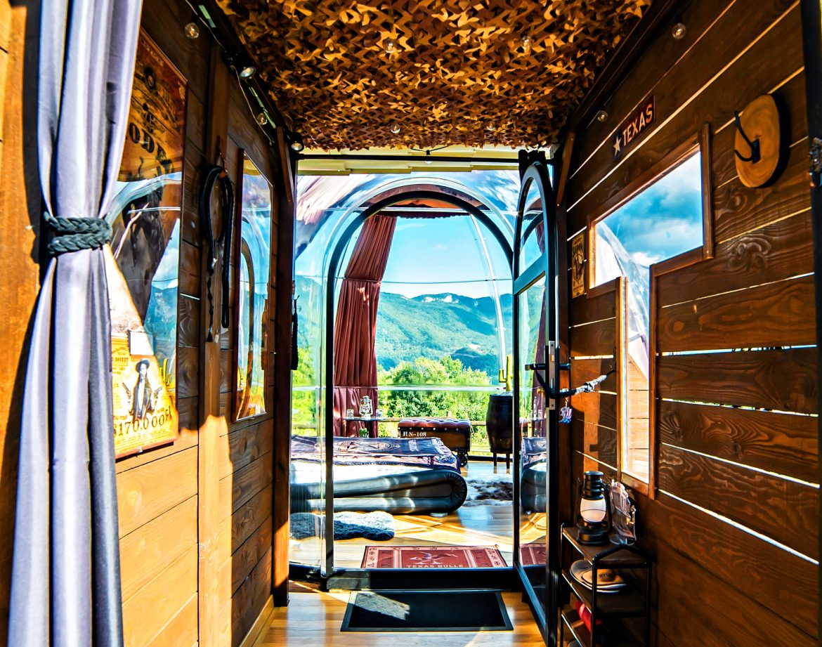Intérieur d'une cabane en bois avec vue panoramique, décor chaleureux et ambiance cosy.