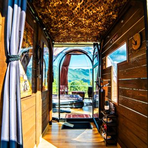 Intérieur d'une cabane en bois avec vue panoramique, décor chaleureux et ambiance cosy.
