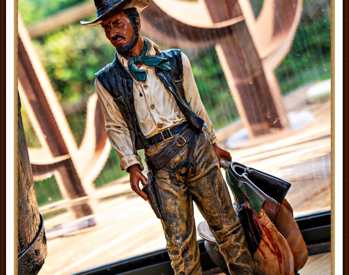 Statue de cowboy dans un hébergement insolite, avec vue sur la nature environnante.