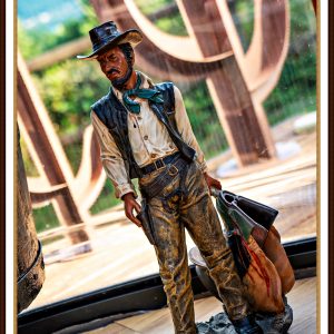 Statue de cowboy dans un hébergement insolite, avec vue sur la nature environnante.