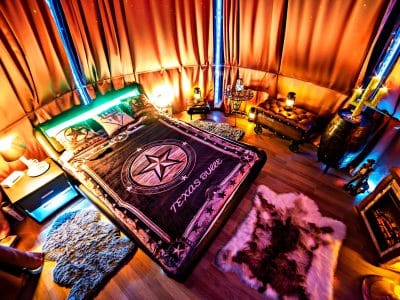Chambre insolite avec lit douillet, ambiance chaleureuse et décor étoilé.