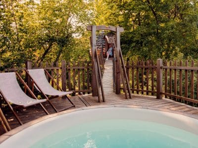Cabane perchée avec piscine, entourée de verdure, offrant une vue apaisante sur la nature.