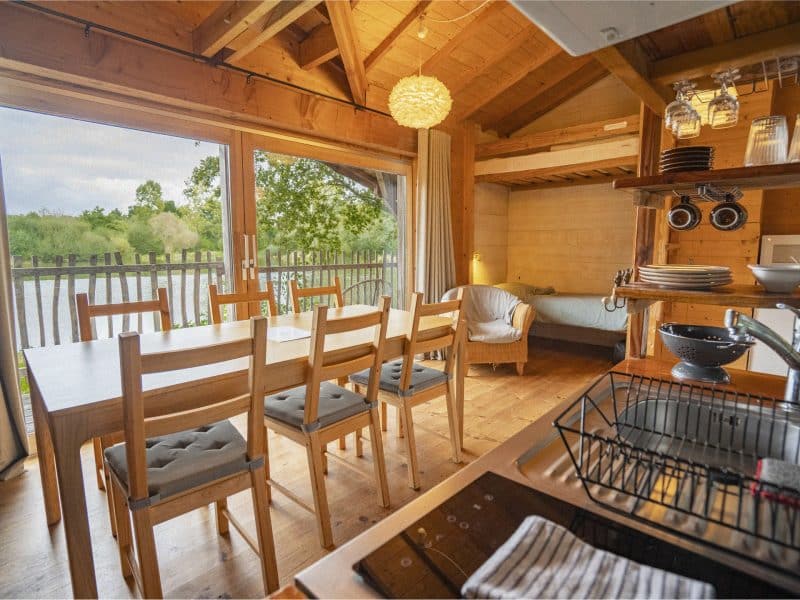 Chalet en bois avec vue sur la nature, lumineux et chaleureux, idéal pour se détendre.
