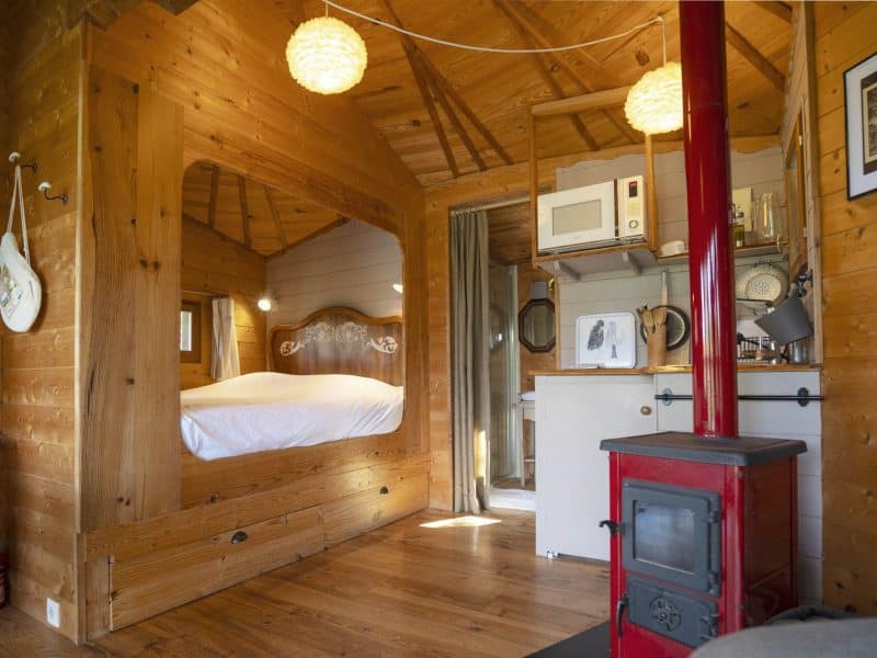 Chalet en bois chaleureux avec un coin cuisine et un poêle à bois.