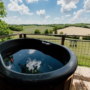 Cabane perchée avec jacuzzi, offrant une vue panoramique sur les champs verdoyants.