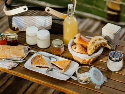 Petit-déjeuner gourmand en pleine nature, avec des viennoiseries et des confitures maison.