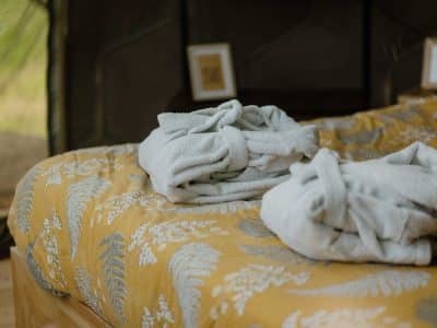 Chambre d'hôtes cosy avec draps en lin et peignoirs moelleux sur un lit douillet.