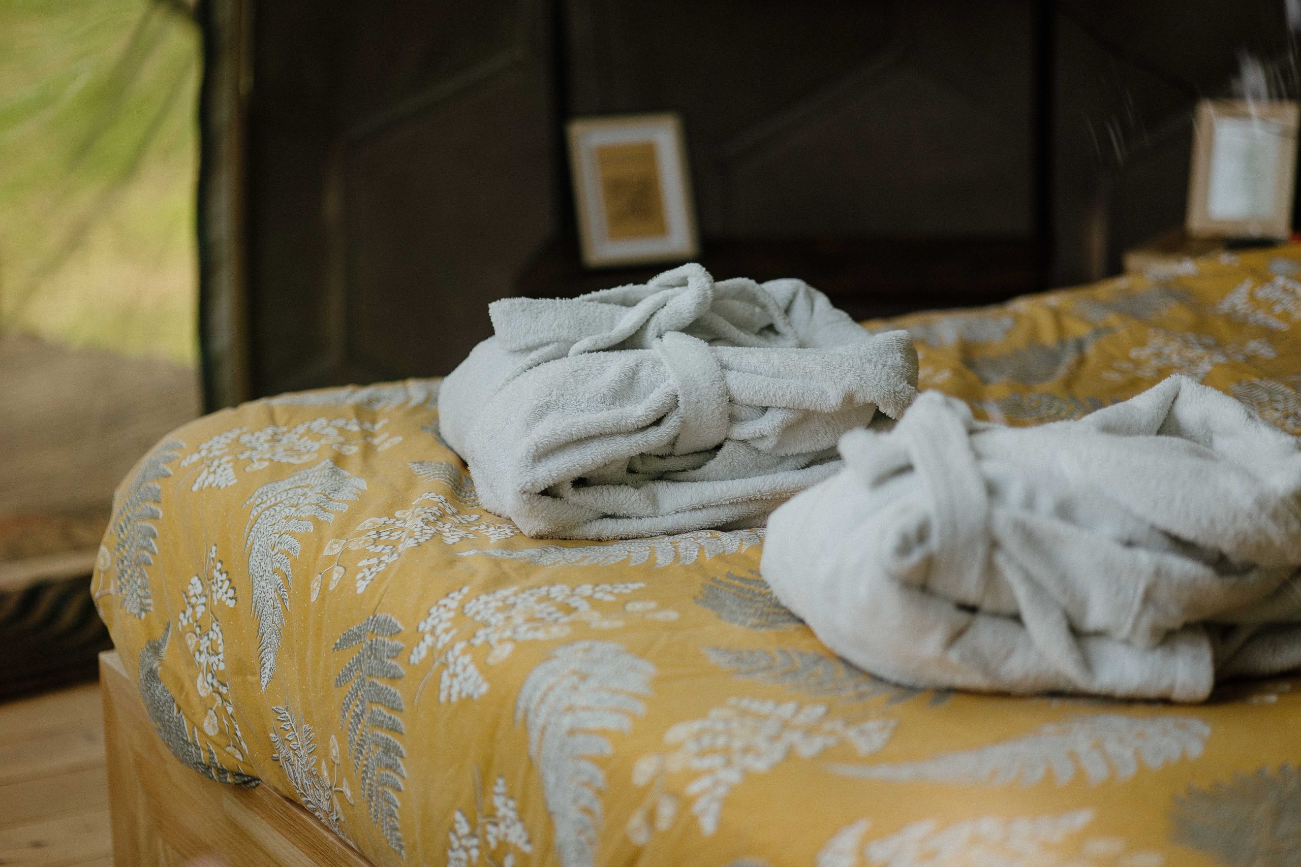 Chambre d'hôtes cosy avec draps en lin et peignoirs moelleux sur un lit douillet.