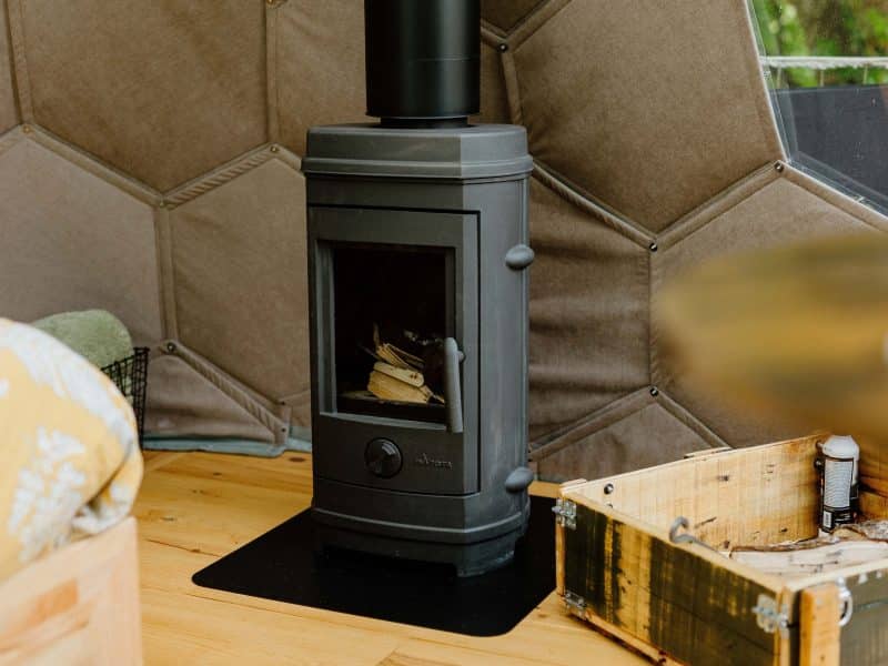 Charmante cabane avec poêle à bois, ambiance chaleureuse et cosy.