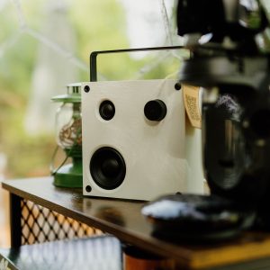 Un hébergement insolite avec un coin café cosy, décoré d'enceintes modernes et d'une lampe vintage.