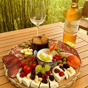 Plateau gourmand avec charcuterie, fromages et vin, idéal pour un séjour en hébergement insolite.
