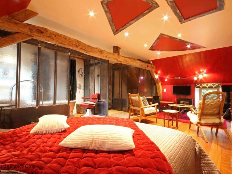 Chambre dhôtes moderne avec un lit douillet et des poutres apparentes.