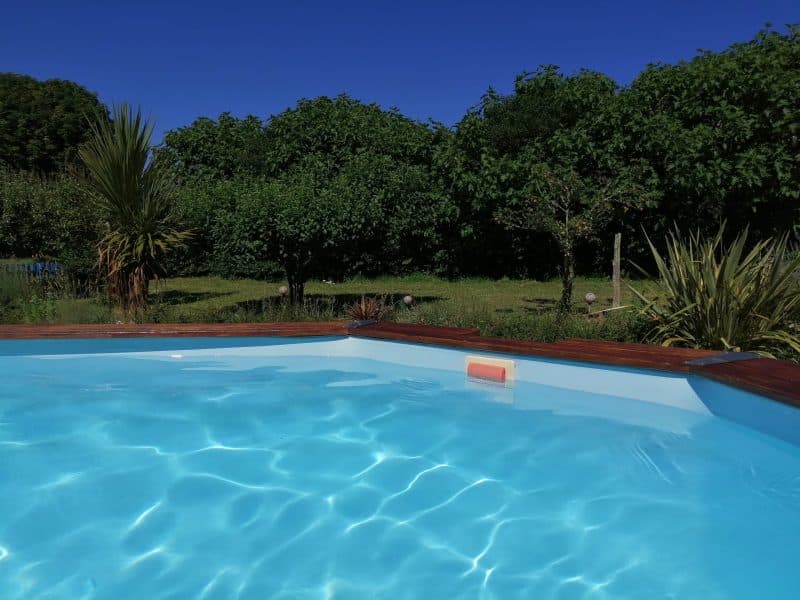 Villa avec piscine, entourée dun jardin verdoyant et ensoleillé.