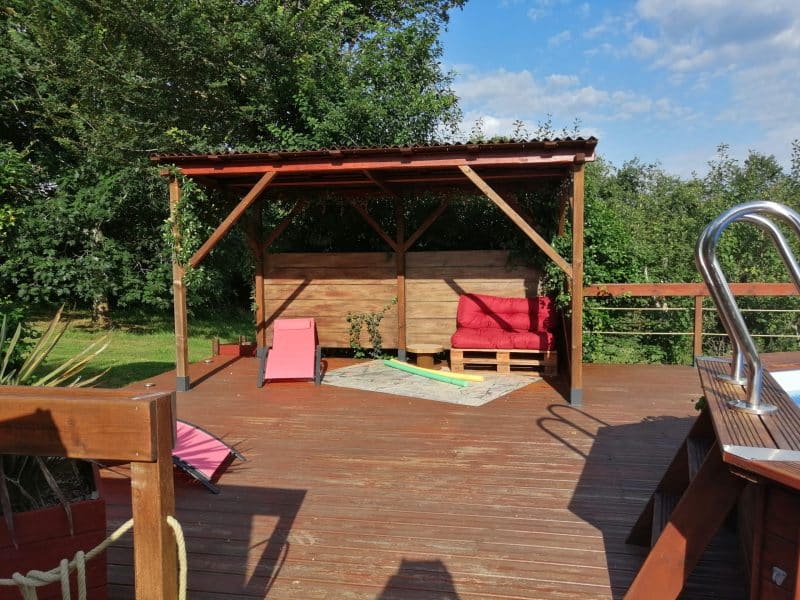Espace détente en bois avec chaises longues, idéal pour un hébergement en pleine nature.